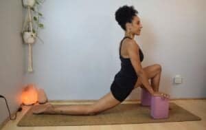 woman doing a low lunge yoga pose with blocks under her hands