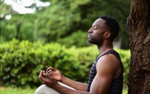 a man doing a loving-kindness meditation under a tree