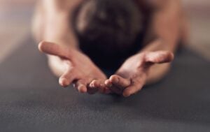 a woman on her yoga mat with her palms facing upwards in isvara pranidhana