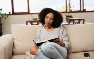 a woman journalling on a sofa