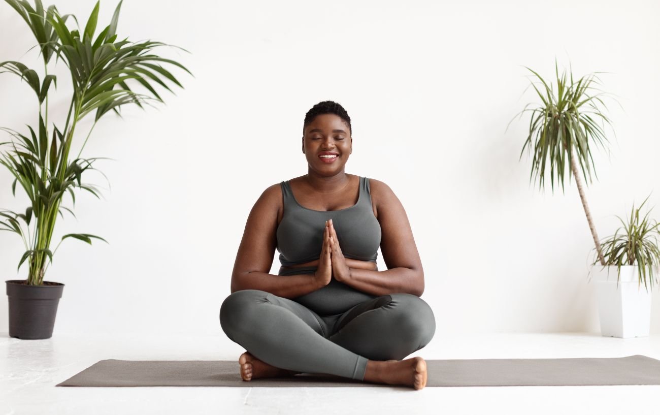 Happy man sitting in a cross-legged yoga pose Stock Photo - Alamy