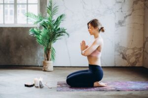 Person sitting in cross-legged meditation pose practicing brahmacharya, the fourth yama of moderation and right use of energy