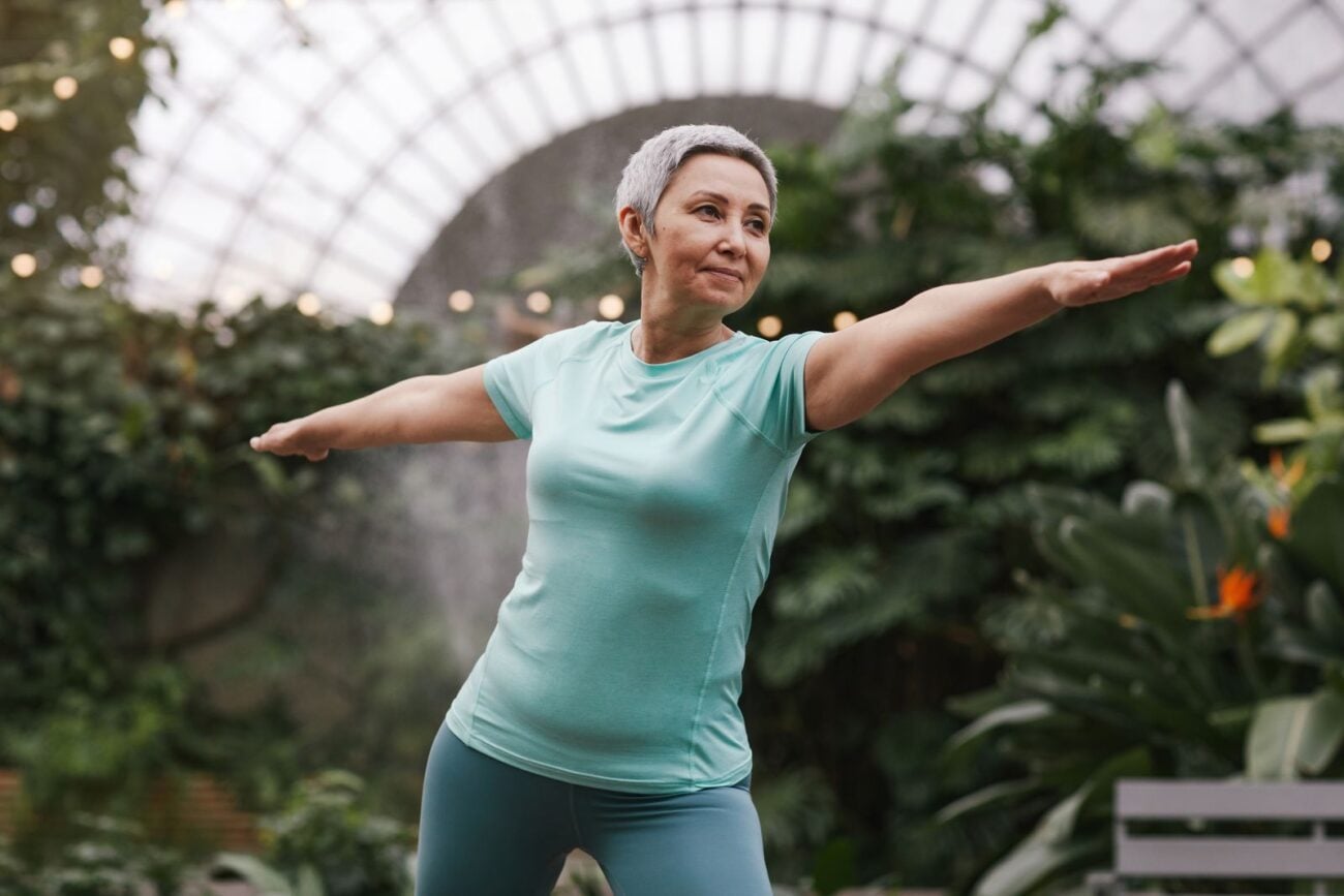 Older woman practicing yoga warrior pose to ease knee arthritis pain and improve joint function